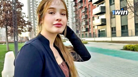 Sexy blonde with tattoos and piercing posing outdoors in urban setting