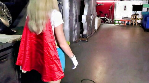 Blonde Supergirl in red cape and short blue skirt posing seductively