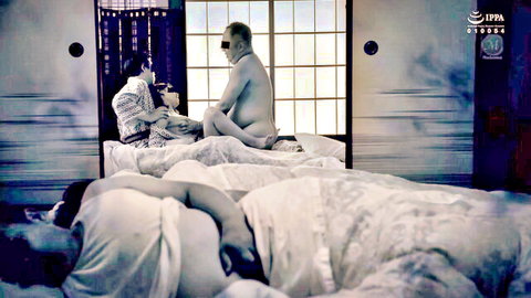 Japanese nude man attended by women in robes, intimate group scene