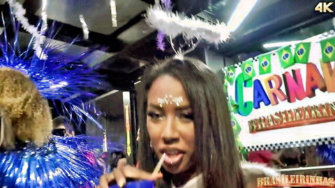 Ebony samba dancer in feathered costume at Brazilian carnival orgy