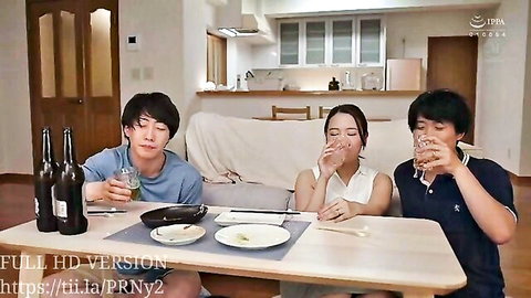 Young Japanese woman and two men drinking beer and eating at kitchen table