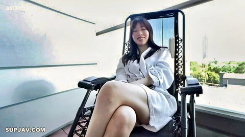 Smiling Asian woman in open white robe, lounging seductively with exposed legs