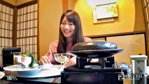Smiling Japanese woman with long hair at dinner table, teasing in pink top