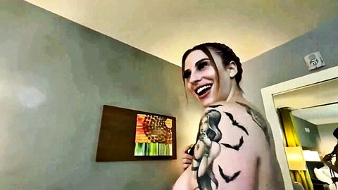 Tattooed brunette smiling nude solo pose in adult video