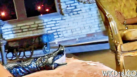 Woman's leg in shiny black boots teased in intimate scene, ready for licking and fucking