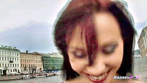 Smiling redhead POV closeup outdoors with city river background