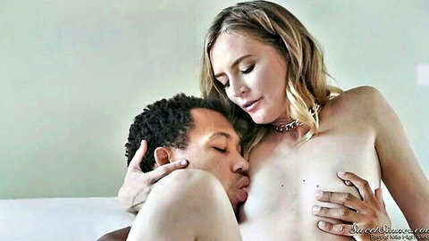 Blonde MILF's perky tits sucked by muscular black stud in bed