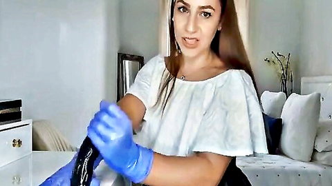 Brunette MILF in white top grips thick black dildo with blue latex gloves