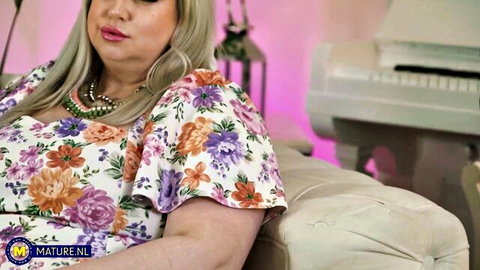 Blonde mature BBW in floral off-shoulder dress posing seductively