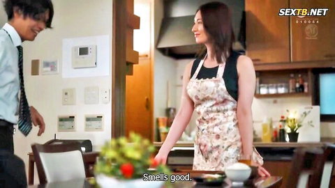 Kimura Rei in floral apron over tank top, smiling in kitchen seduction