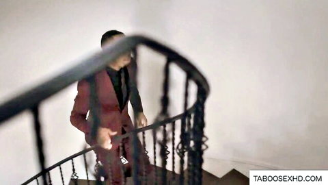 Cheating wife in red suit sneaking upstairs while husband nearby