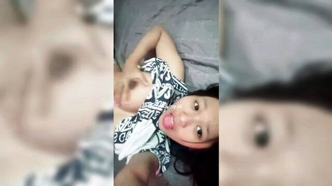 Rara Nadifa sexy Asian selfie in low-cut black dress, smiling playfully