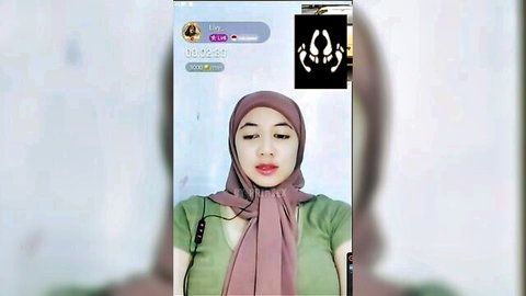 Hijabi woman in pink scarf and green top on amateur video call