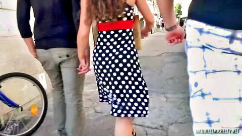 Brunette in short polka dot dress walking hand-in-hand with boyfriend on street teasing big ass and legs