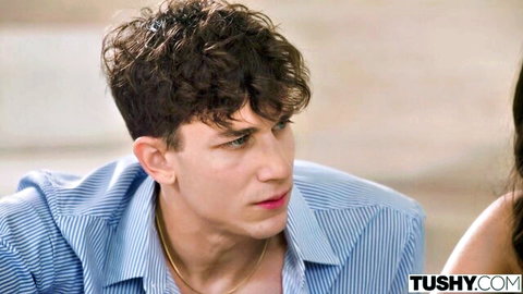 Sawyer Cassidy in blue shirt, intense gaze during anal scene tease
