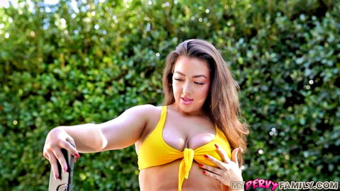 Busty brunette in yellow bikini teasing her large breasts outdoors