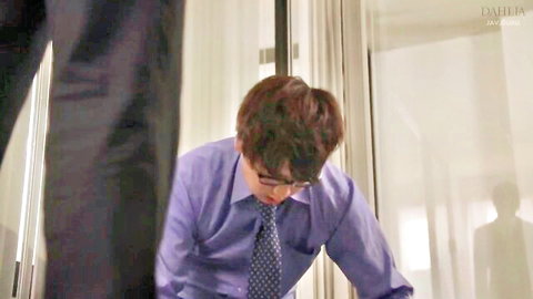 JAV office scene: man in lilac shirt and tie bending over beautiful secretary