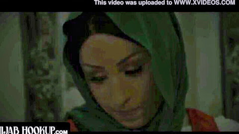 Closeup of stunning Arab woman in green hijab gazing down intensely