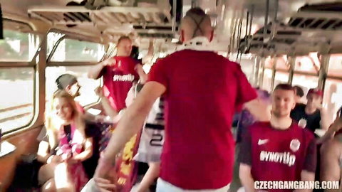 Blonde woman surrounded by horny men in red shirts on crowded Czech bus gangbang