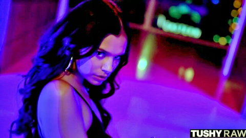 Seductive brunette with hoop earrings poses intensely in neon club lights before anal action