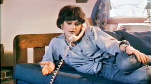 Vintage MILF lounging on bed talking on phone with legs spread in tight jeans
