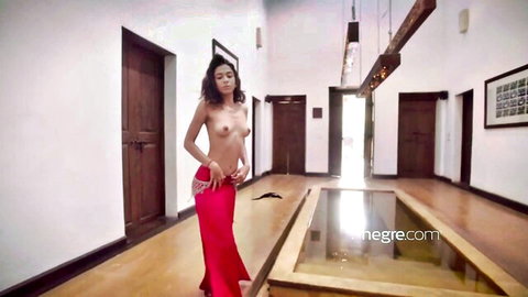 Topless exotic dancer in flowing red skirt performs sensual belly dance