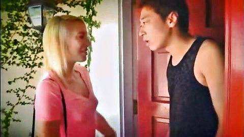 Blonde woman in pink top flirts intimately with fit Asian guy at outdoor doorway