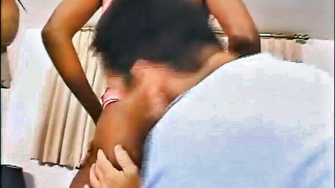 Two ebony women in intimate bathroom embrace, pink and white lingerie