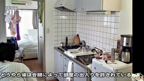 Japanese man sitting in messy kitchen with dishes, hanging lingerie, and bedroom visible in amateur setup