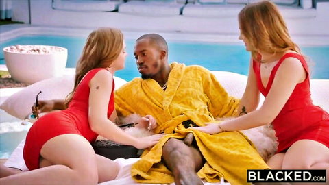 Two redhead babes in skimpy red bikinis stroke massive BBC through open robe in poolside threesome