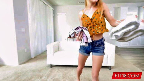 Fit teen Natalie Knight in orange crop top and denim shorts doing laundry