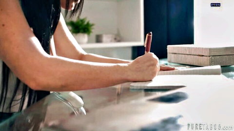 Jennifer White in white blouse writing at desk, showing cleavage