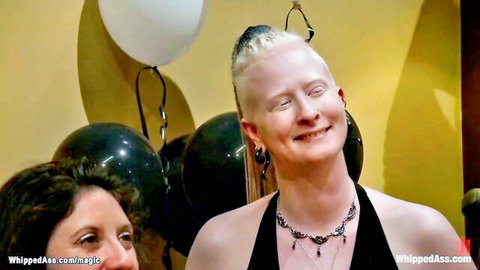 Justine Joli with white mohawk smiling at dyke party in black dress