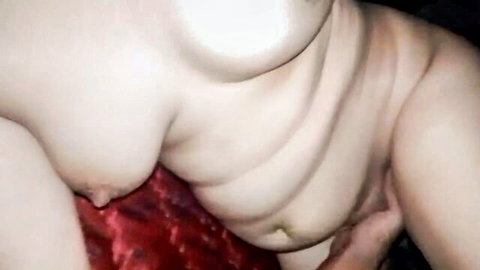 Pale nude woman with perky tits touches tight pussy on red sheets