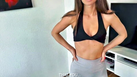Slim Caucasian MILF posing in revealing black halter top and gray leggings