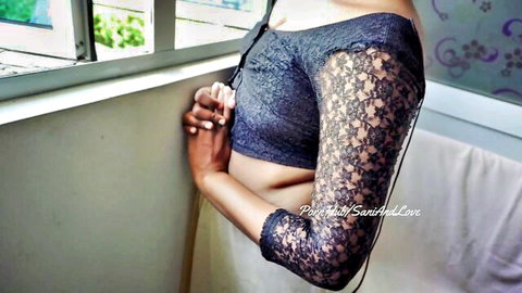 Sexy Indian babe in sheer lace blouse exposing midriff and curves by window