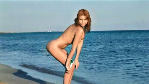 Nude redhead bends over on beach exposing her bare ass and pussy lips