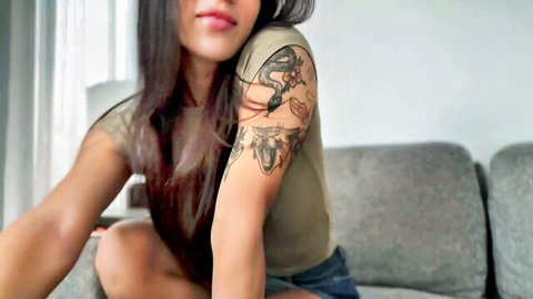 Anna Cherry7 posing seductively with dragon tattoo on arm in green top