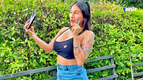 Curvy Latina with big tits in black bra top blowing kiss in outdoor selfie