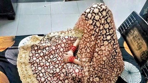 Sexy Indian woman in embroidered saree poses teasingly from behind on bed