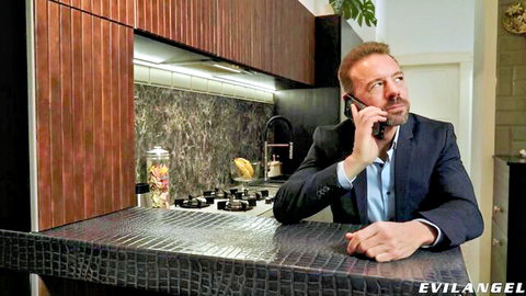 David Perry in suit, intense phone call in kitchen