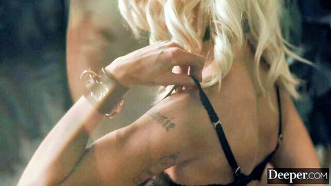 Emma Rosie tattooed blonde in black lingerie, back view from Deeper scene