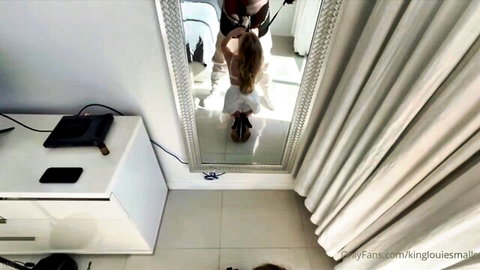 Alexandra Qos kneeling in white dress for Louie Smalls in mirror tease on OnlyFans