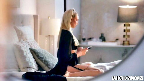 Blonde stunner Kenzie in silky black dress, lounging seductively on bed