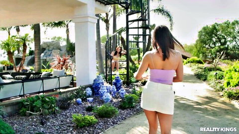 Brunette with big tits in pink crop top and white mini skirt teasing outdoors