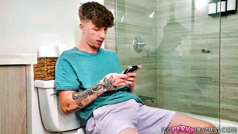 Tattooed guy shocked on toilet checking phone in bathroom