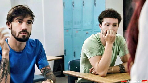 Two fit male students with tattoos sharing intense gaze in forbidden lust scene