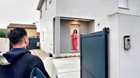 Charline in sexy red dress warmly welcoming man at home door