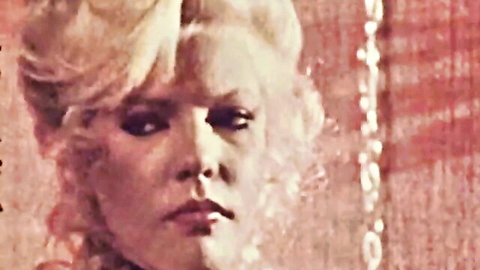 Seductive blonde in intense gaze from classic XXX bartender video