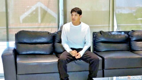 Fit Asian man in white shirt and black pants sitting on couch, step-brother tease
